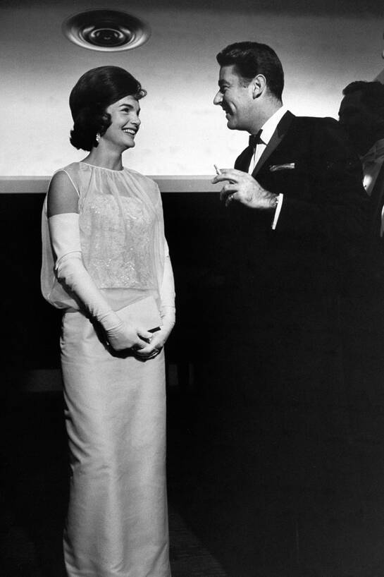 Jackie Kennedy in a silk sleeveless gown, with Peter Lawford, at the Inauguration Ball at White House Washington DC, 20 January 1961