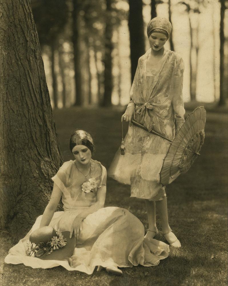 Model Marion Morehouse in a bouffant dress and actress Helen Lyons in a long sleeve dress by Kargère; masks by the illustrator W.T. Benda, photo by Edward Steichen, 1926
