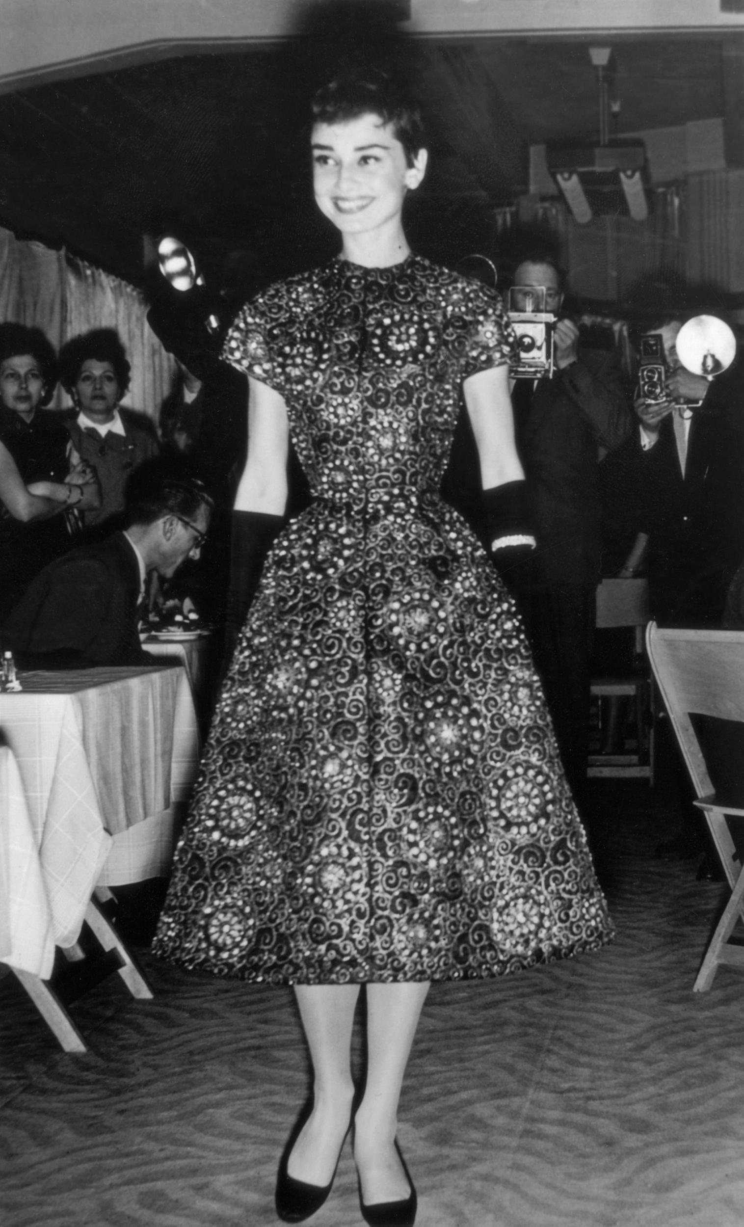 Audrey Hepburn in patterned dress at an Amsterdam fashion show, November 1954
