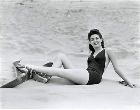 Elegant style icon wardrobe essentials: Ava Gardner in swimwear, a one piece swimsuit in solid color