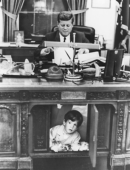 John F. Kennedy Jr. under the desk of his father John F. Kennedy's desk in his office, White House