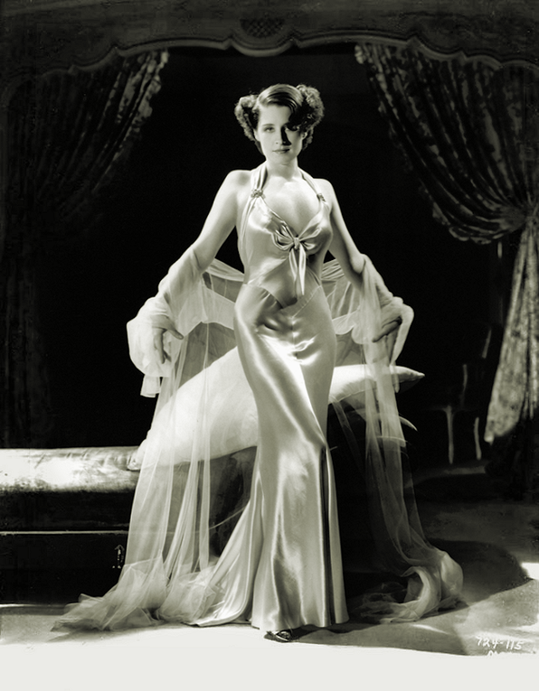 Norma Shearer in a backless gown designed by Adrian in publicity photo for film Riptide(1934)