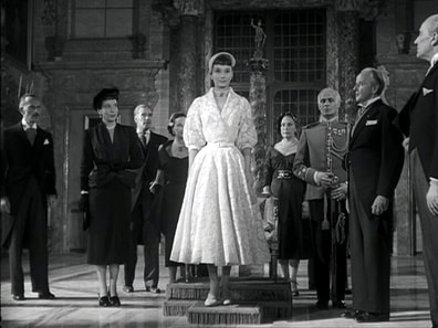 Audrey Hepburn movie costume white lace midi dress with shawl collar in film Roman Holiday (1953) designed by Edith Head