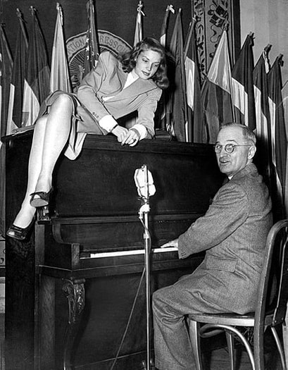 20 year old Bacall lounges on top of the piano while Vice President Harry S. Truman plays for servicemen at the National Press Club Canteen in Washington, D.C. (February 10, 1945)