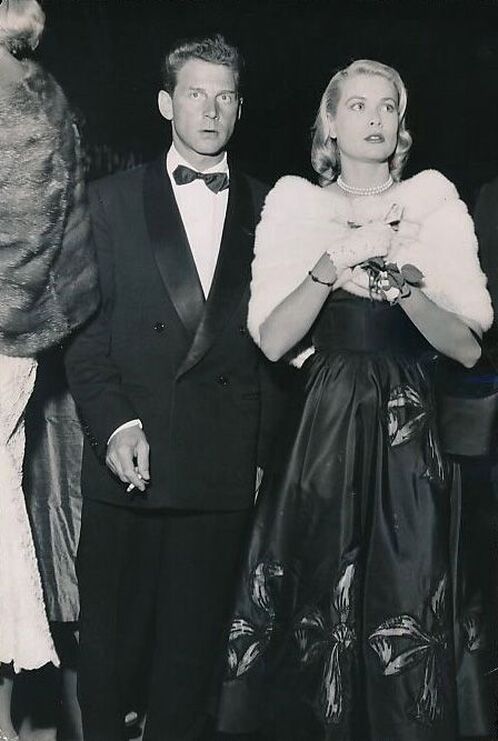 Elegant style icon wardrobe essentials: Grace Kelly in black dress, with Jean-Pierre Aumont. Cannes Film Festival 1955.