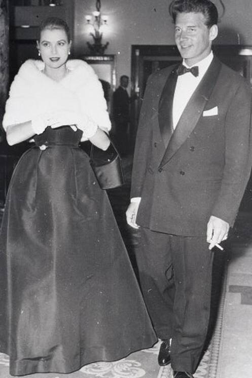 Elegant style icon wardrobe essentials: Grace Kelly in black dress with Jean-Pierre Aumont. 1955