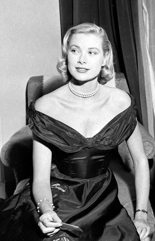 Elegant style icon wardrobe essentials: Grace Kelly in black dress, Cannes Film Festival 1955.