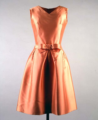 Jackie Kennedy’s apricot silk ziberline dress she wore for the boat ride on lake Pichola, Udaipur India, 17 March 1962, designed by Oleg Cassini, sleeveless knee length featuring v neckline bodice and a line skirt with bow detail at waist.
