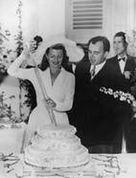 Aly Khan and Rita Hayworth American actress on their wedding day cutting the wedding cake