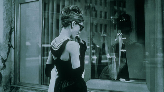 Elegant style icon wardrobe essentials: The Little Black Dress: Audrey Hepurn in black dress in film Breakfast at The Tiffany's designed by Hubert de Givenchy