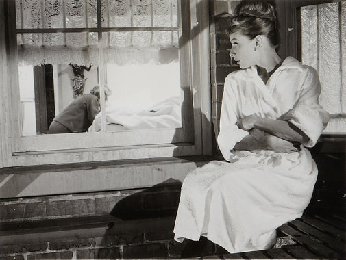 Audrey Hepburn on balcony watching her neighbour in film Breakfast at Tiffany 1961