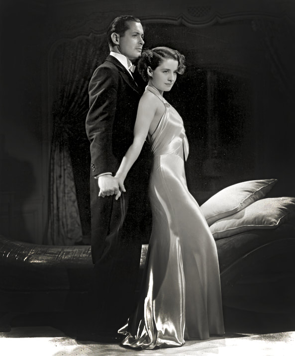 Norma Shearer in a backless gown designed by Adrian and Robert Montgomery in publicity photo for film Riptide(1934)