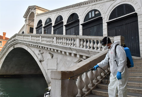 An employee of the municipal company Veritas sprays disinfectant in public areas at the Rialto Bridge in Venice, Italy, on Wednesday, March 11, 2020.Marco Sabadin / AFP - Getty Images