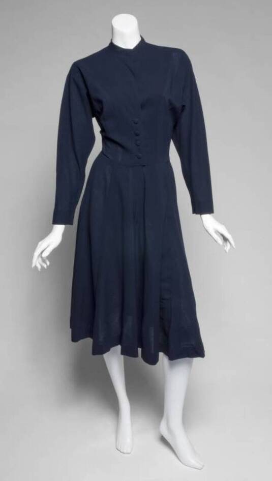 Greta Garbo's navy blue wool crepe dress made by Valentina circa 1949. The long-sleeve dress has four-button closure with a hook and eye at the collar. Valentina label sewn in at waist.