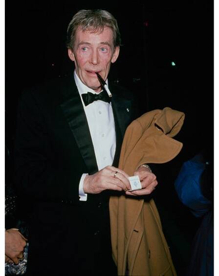 Peter O'toole holds a cigarette at home