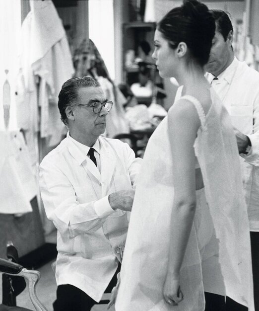 Cristobal Balenciaga working in his atelier with a model