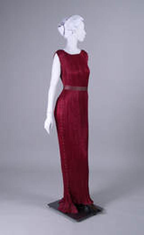 a red sleeveless delphos dress created by Mariano Fortuny in 1936