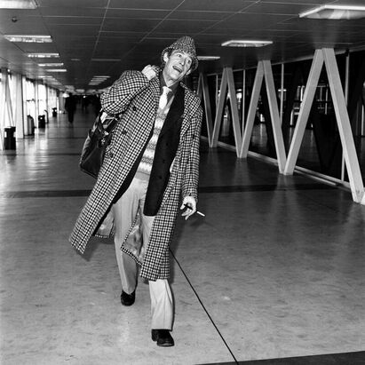 The eccentric elegance of this Irish man Peter O'toole: Peter O'Toole at Heathrow airport London prior to flying to New York, 1982
