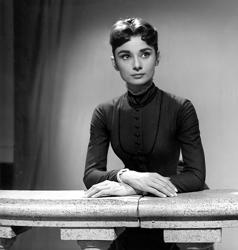 Elegant style icon wardrobe essentials: Audrey Hepburn in little black dress on the set of film Mayerling(1957)