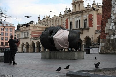 A sculpture in the centre of Krakow is seen with a mask, Poland