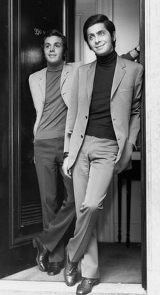 young valentino garavani with giancarlo giammetti standing beside door in turtle neck sweater elegancepedia
